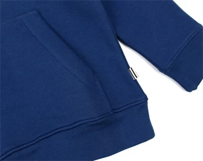 Nærbillede af blå mads noergaard hættetrøje med kængurulomme og flag label